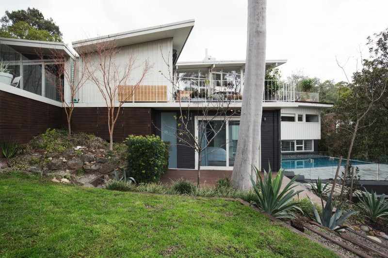 Mid century modern home with a pool and a butterfly roof (Photo by Jodie Johnson - stock.adobe.com)
